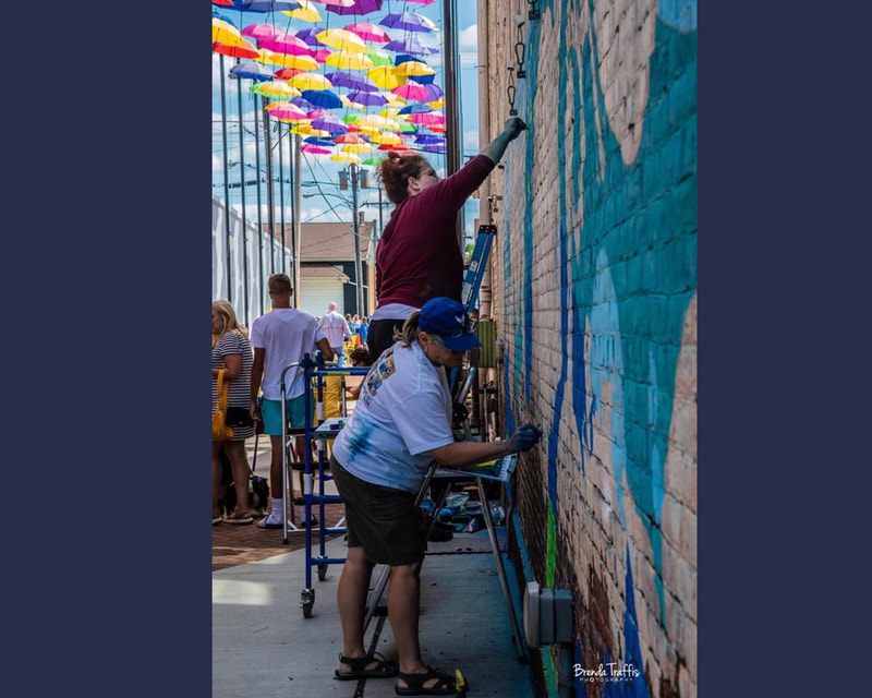 Chalk artists Sheryl Lazenby,  Jennifer Russell, and Jan Solari in Umbrella Alley, Louisville, OH.